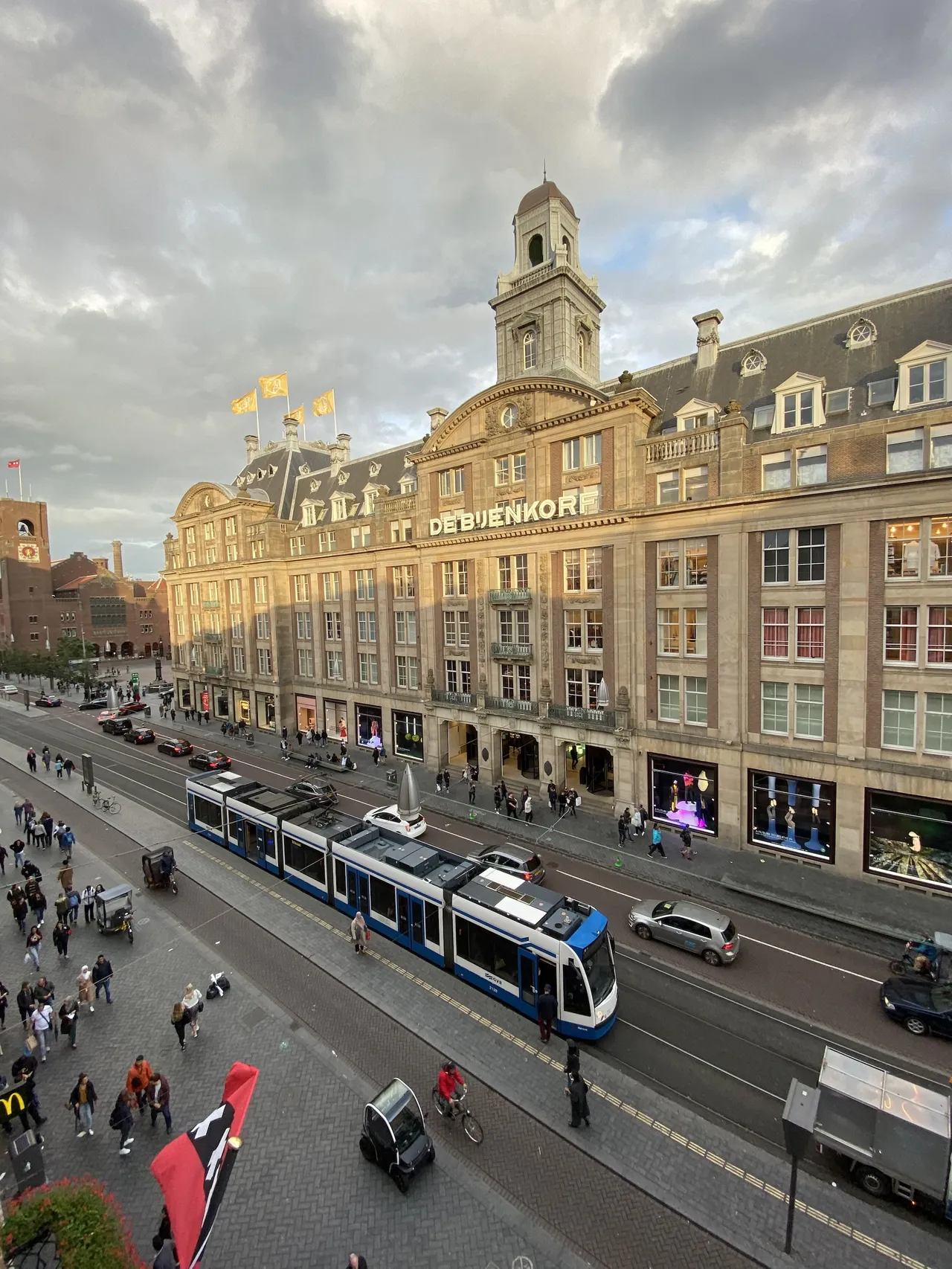 A city scene showing a grand hotel with a tram and tramline in the foreground.