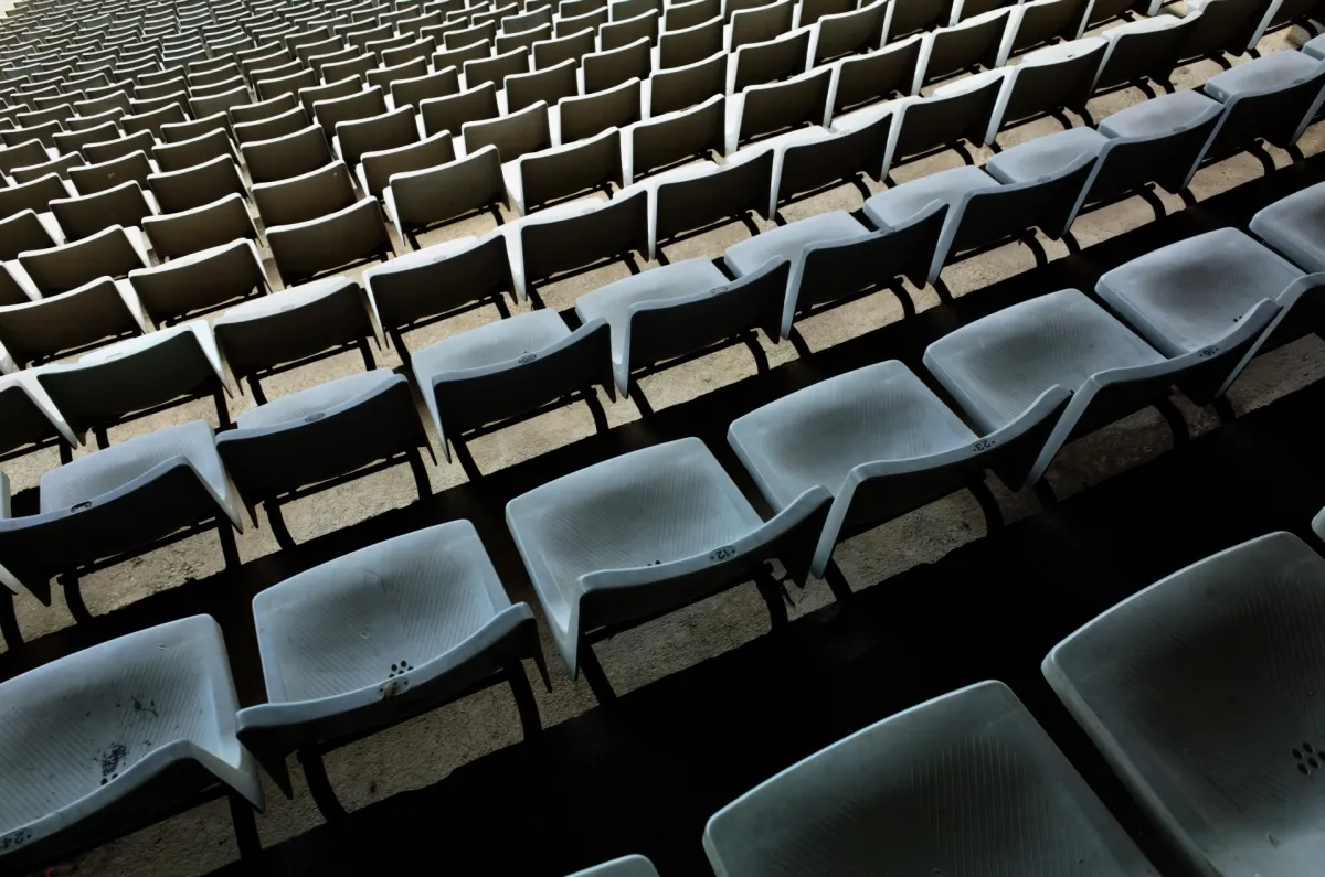 Rows of empty grey stadium seats.