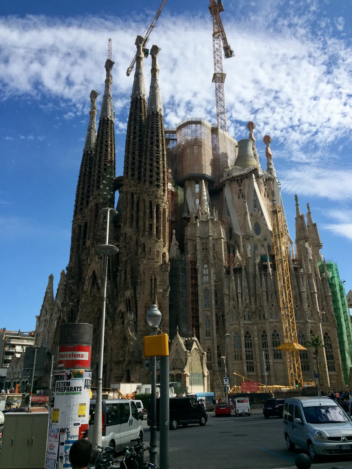 The Sagrada Família under construction, with cranes rising behind its spires.