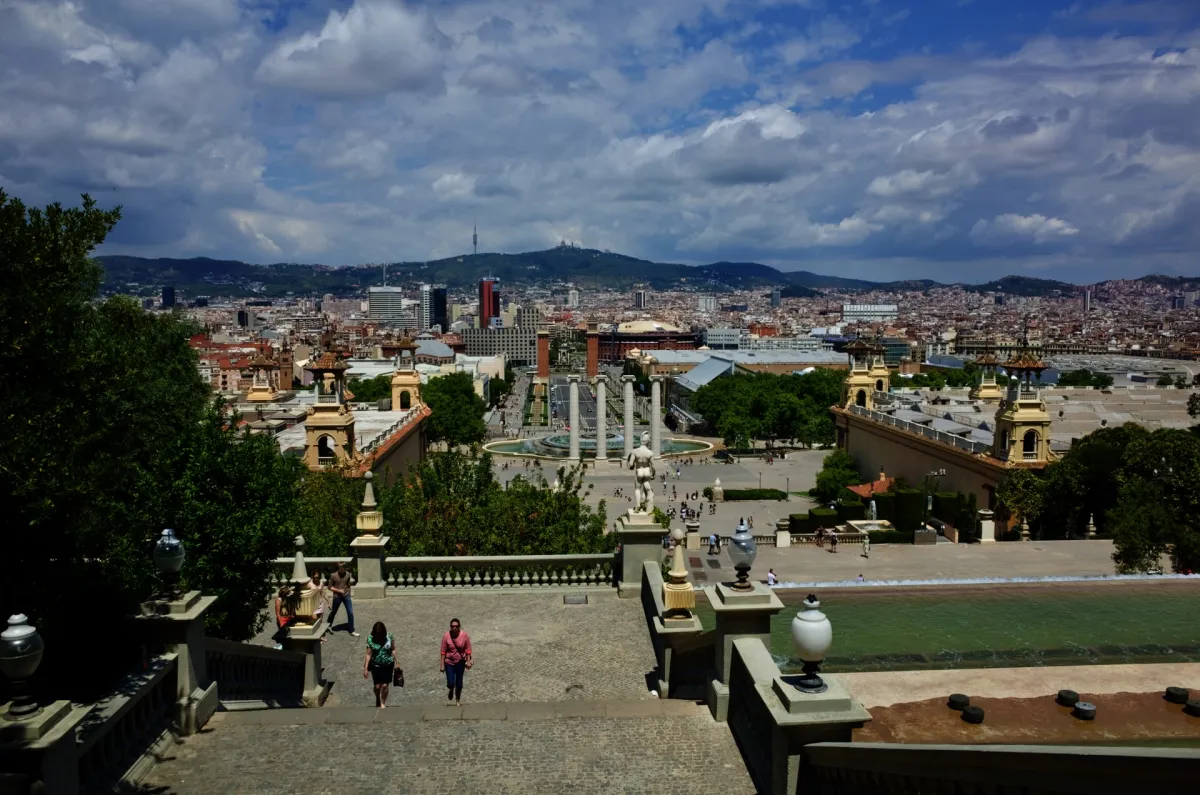 A view over the city from a hilltop staircase, with columns and gardens below.