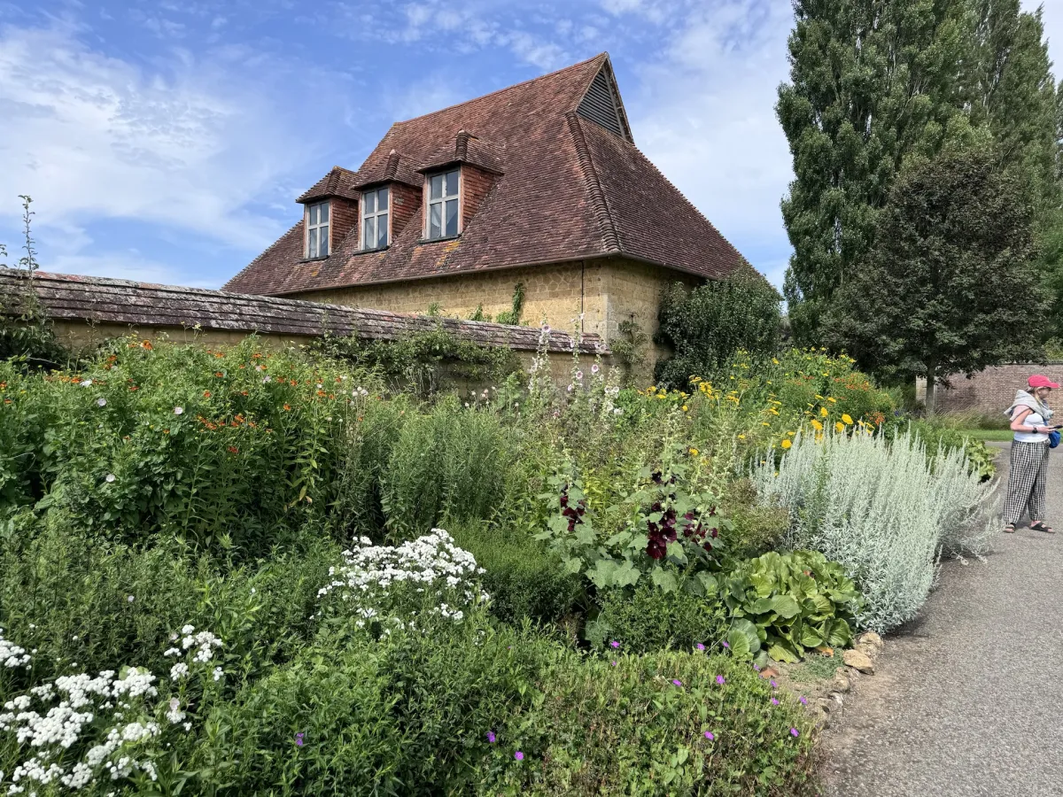 A tiled garden building above a deep herbaceous border.