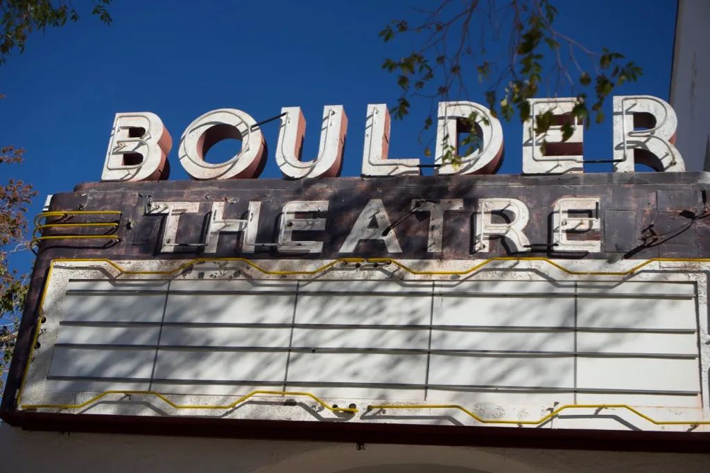 The weathered marquee of the Boulder Theatre, its raised lettering above a blank signboard.