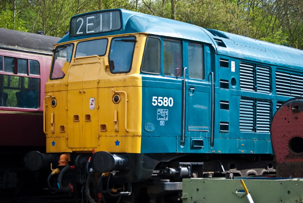 A blue and yellow diesel locomotive numbered 5580, with headcode 2E11.