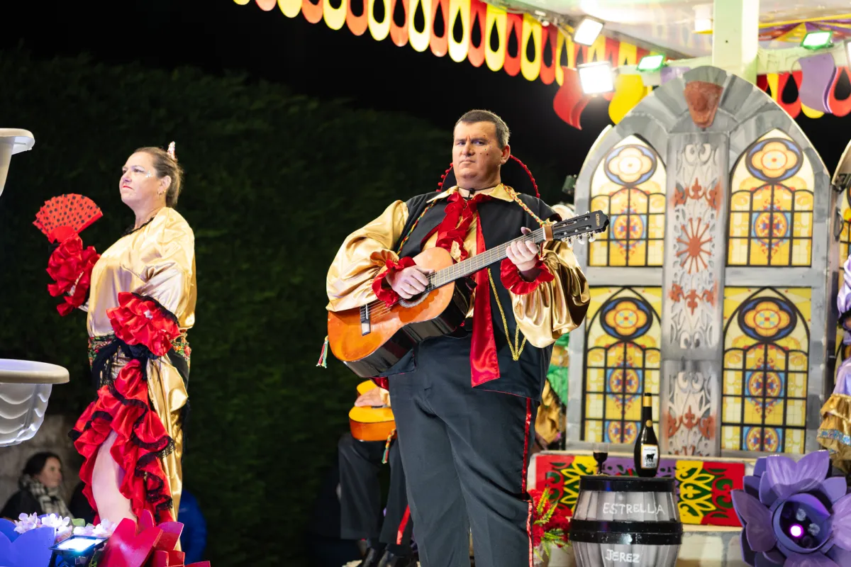 A guitarist and a dancer in Spanish costume on an illuminated float.