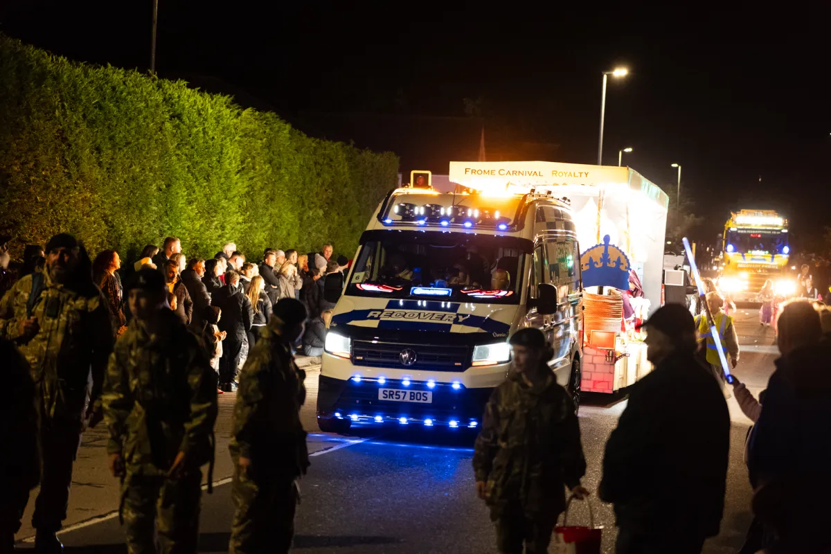 A recovery truck at the head of the procession, with cadets lining the road.