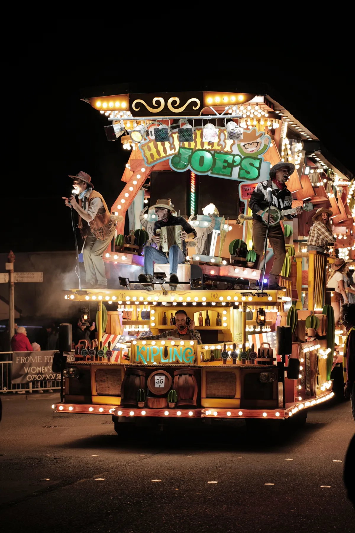 The Hillbilly Joe's float lit with hundreds of bulbs, performers on two decks.