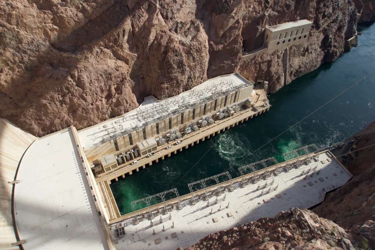 Looking down from the dam onto the generator halls and turquoise water below.