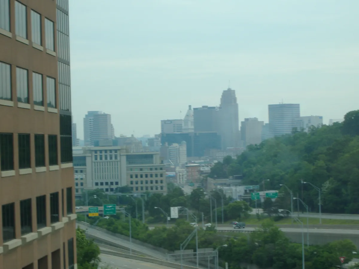 A hazy view over a city, with an interstate and office blocks below.