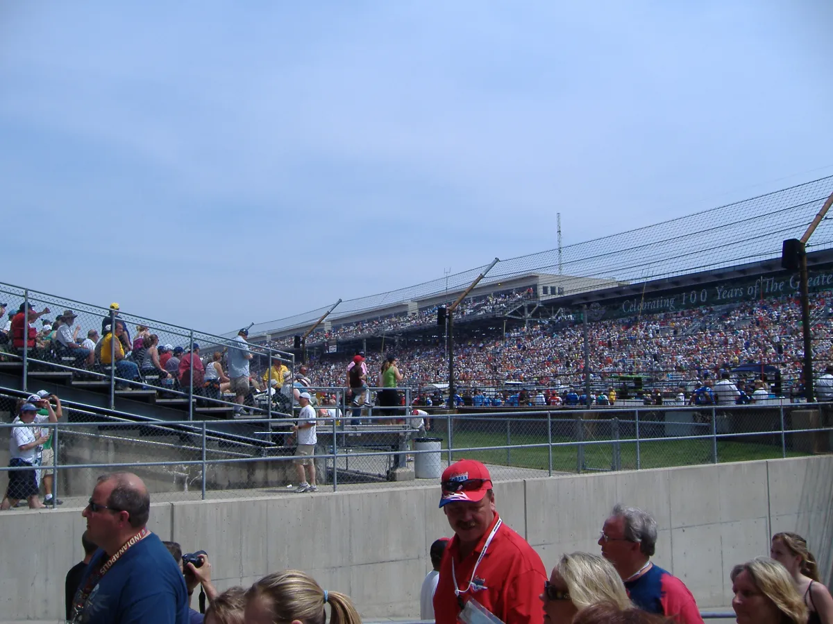 Spectators and grandstands at a motor racing circuit on a clear day.