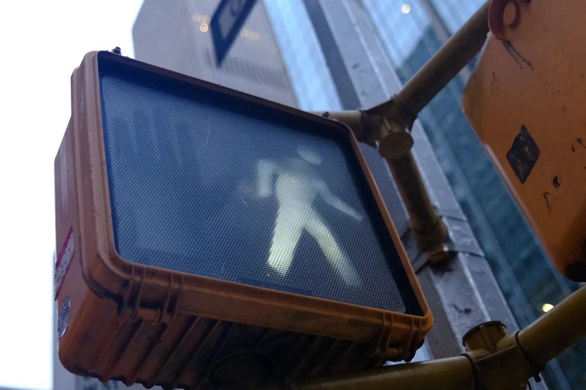 A pedestrian crossing signal showing the white walking figure.