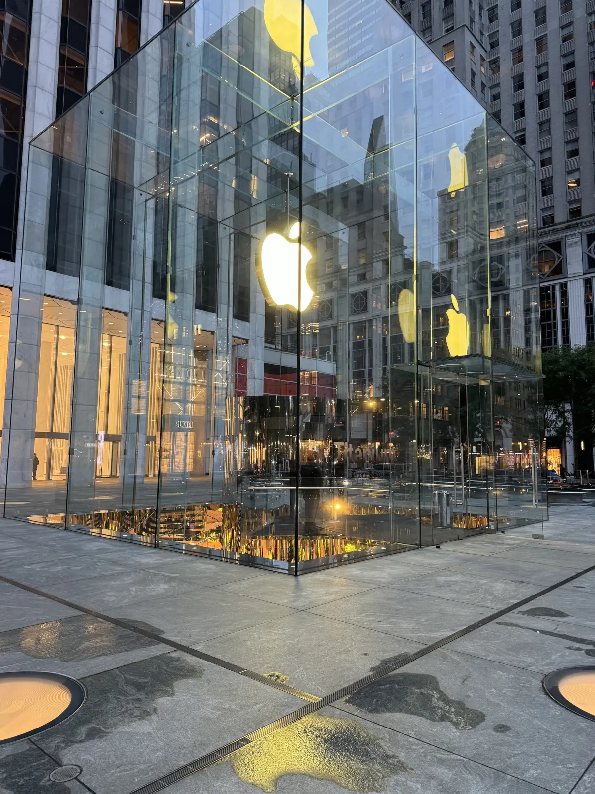 The glass cube entrance to the Fifth Avenue Apple Store at dusk.