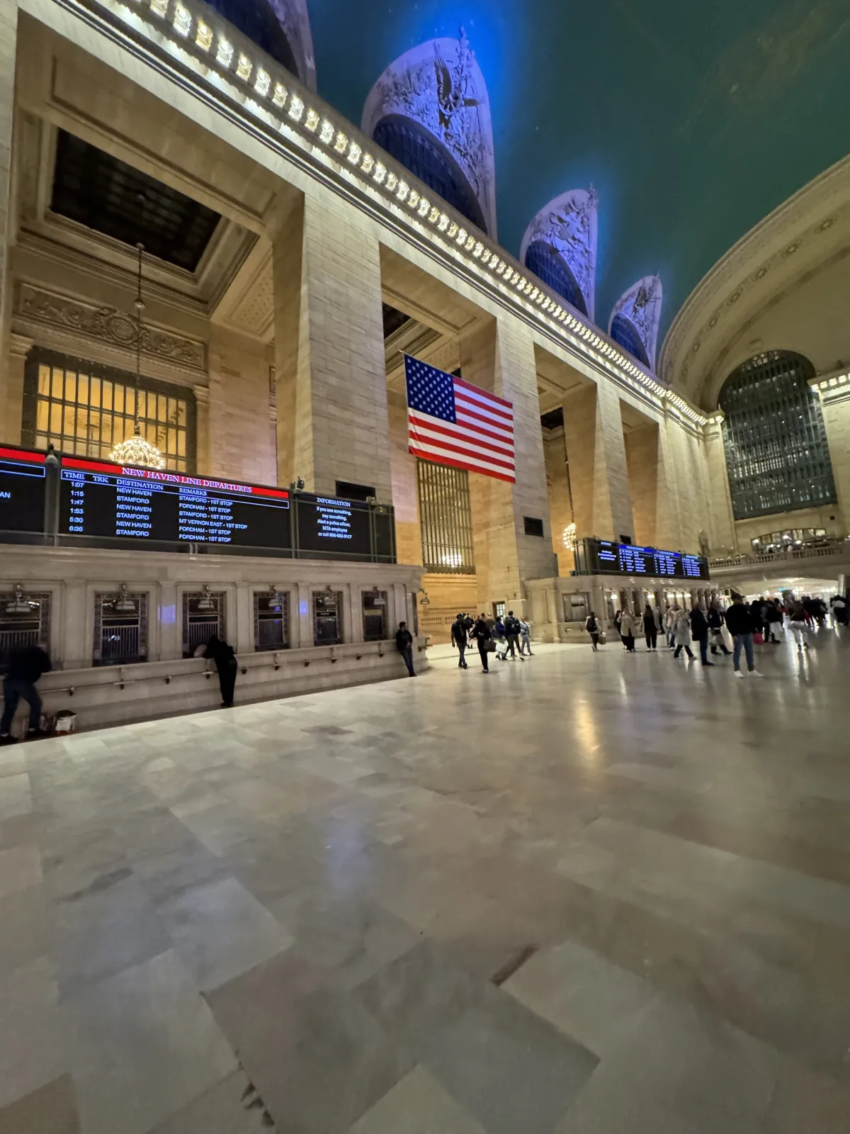 The main concourse of Grand Central Terminal, with a large American flag hanging above.