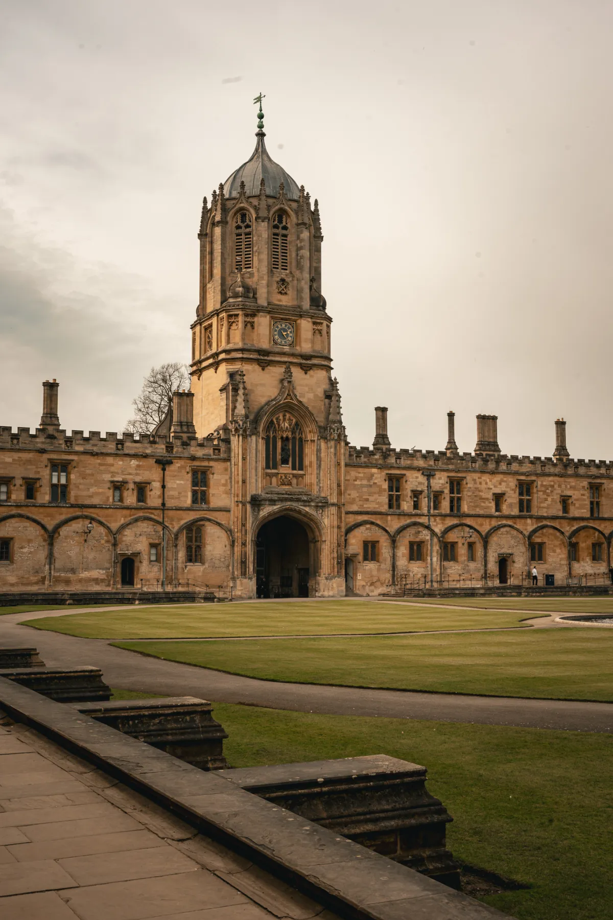 Tom Tower above the gateway of a college quadrangle, with a lawn in front.