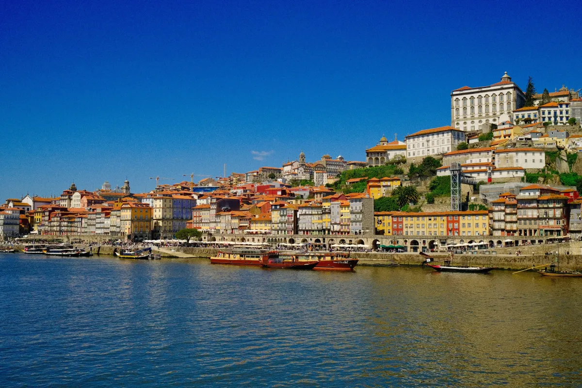 Porto's Ribeira waterfront seen from across the Douro, its colourful houses rising up the hillside.