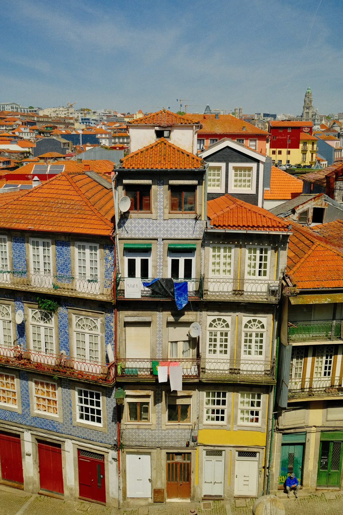 A tall, narrow townhouse faced with patterned azulejo tiles, washing strung across its windows.
