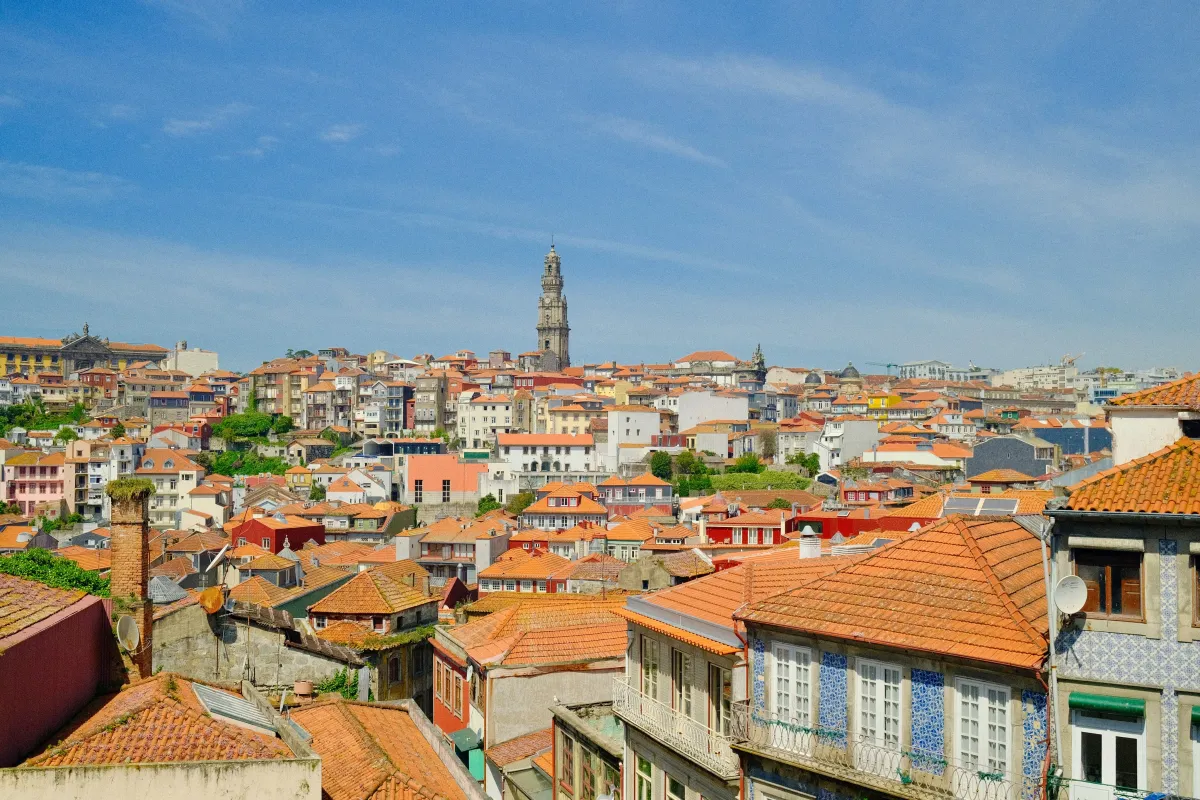 A panorama across Porto's rooftops with the Clérigos bell tower rising in the centre.
