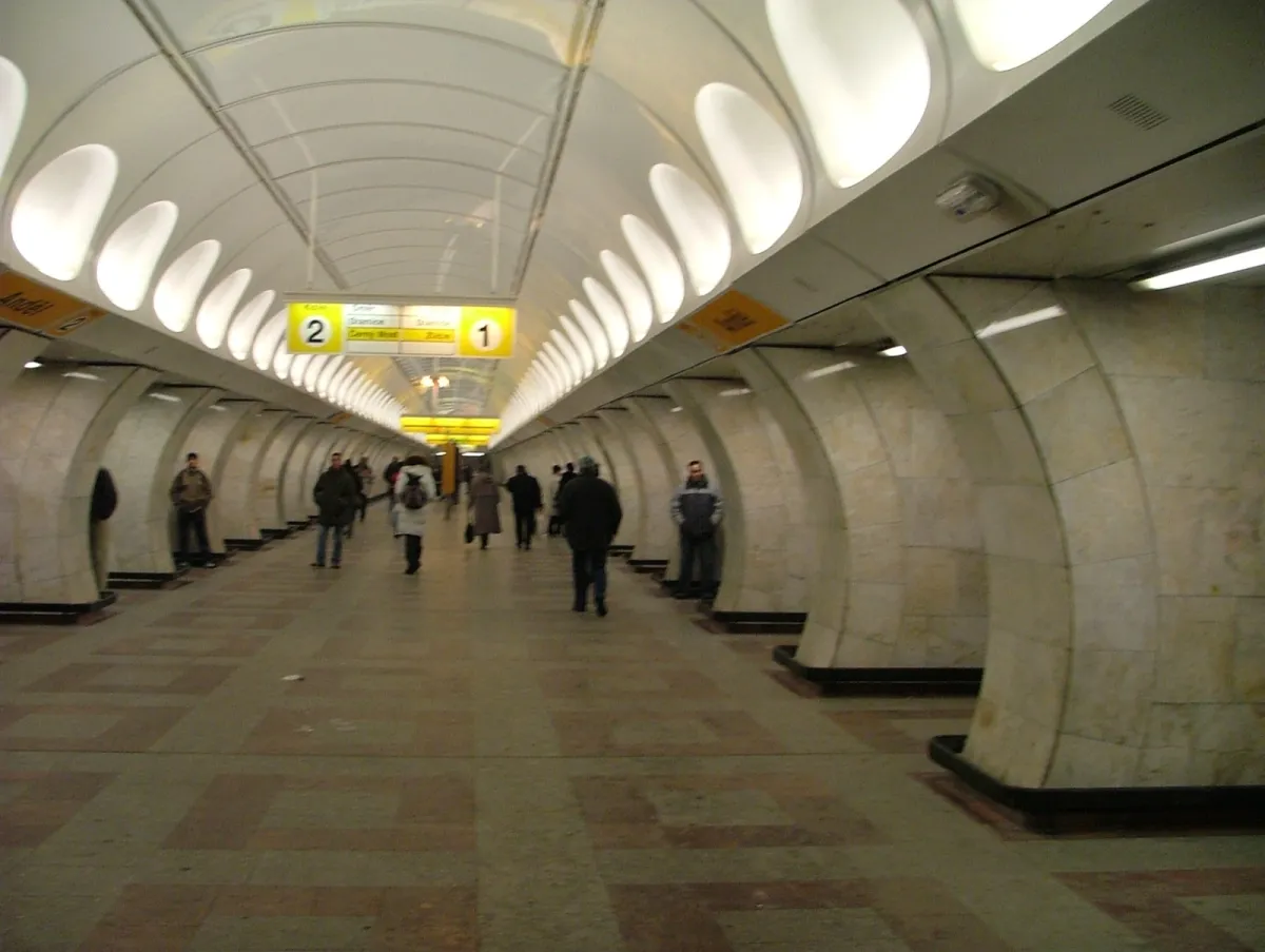 An underground station platform with a vaulted ceiling and numbered yellow signs.