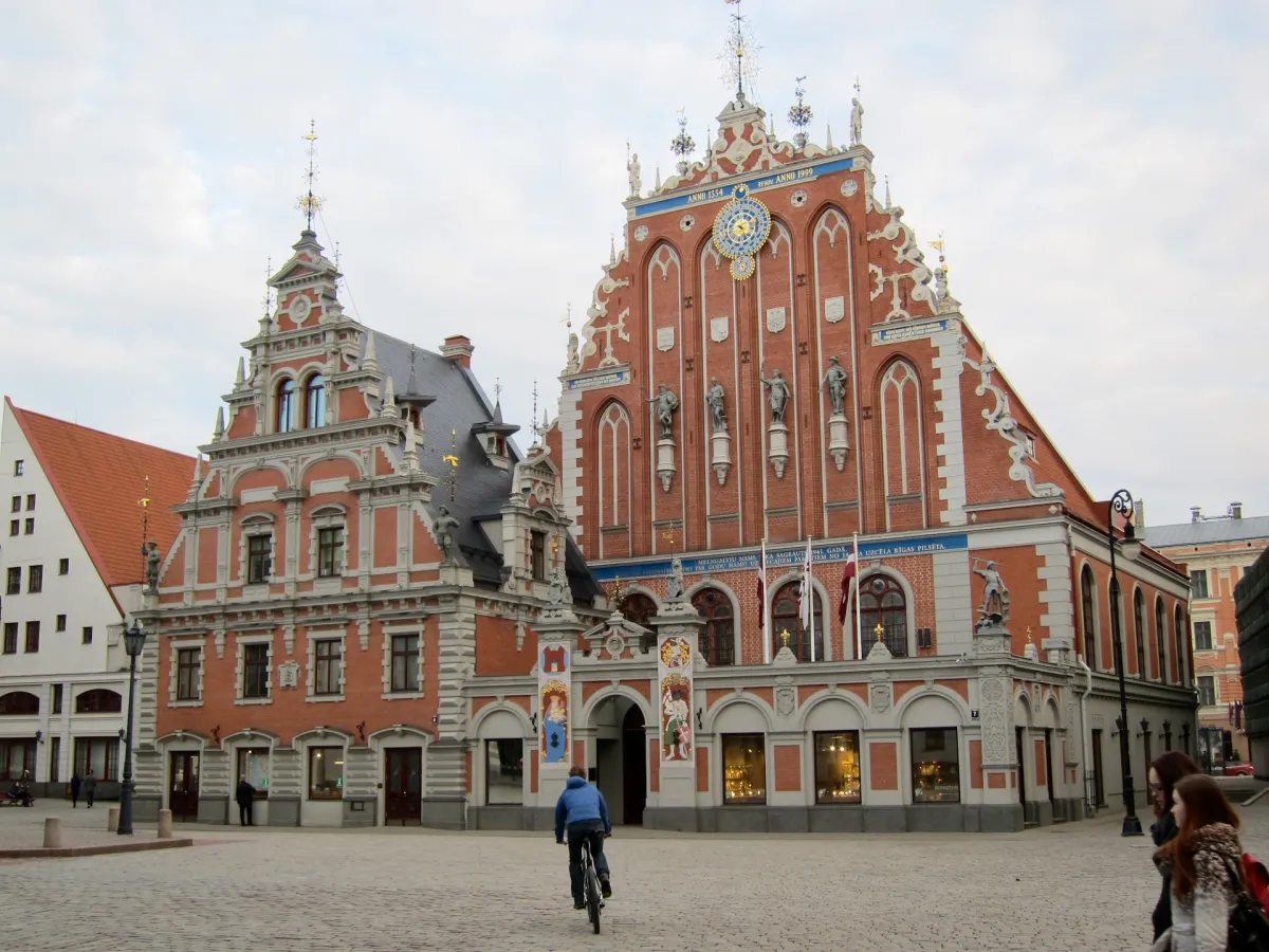 The ornate red brick facade of the House of the Blackheads on a cobbled square.