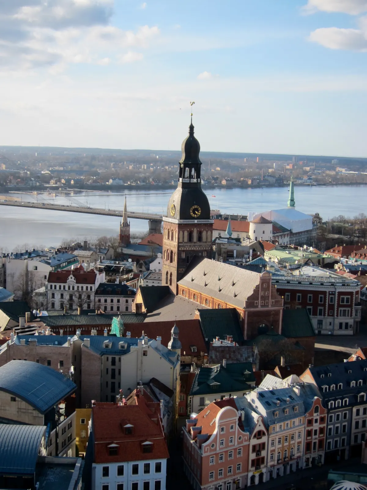 Riga's rooftops seen from above, with the cathedral tower and the river beyond.