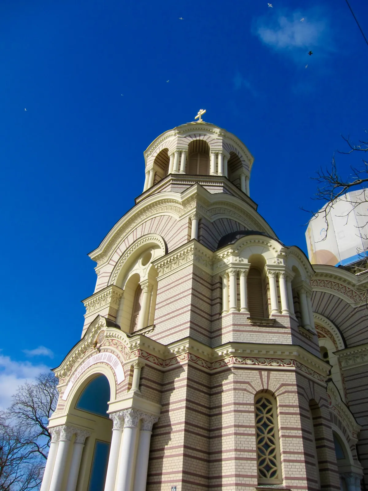 The tiered stonework and dome of an orthodox cathedral against a deep blue sky.