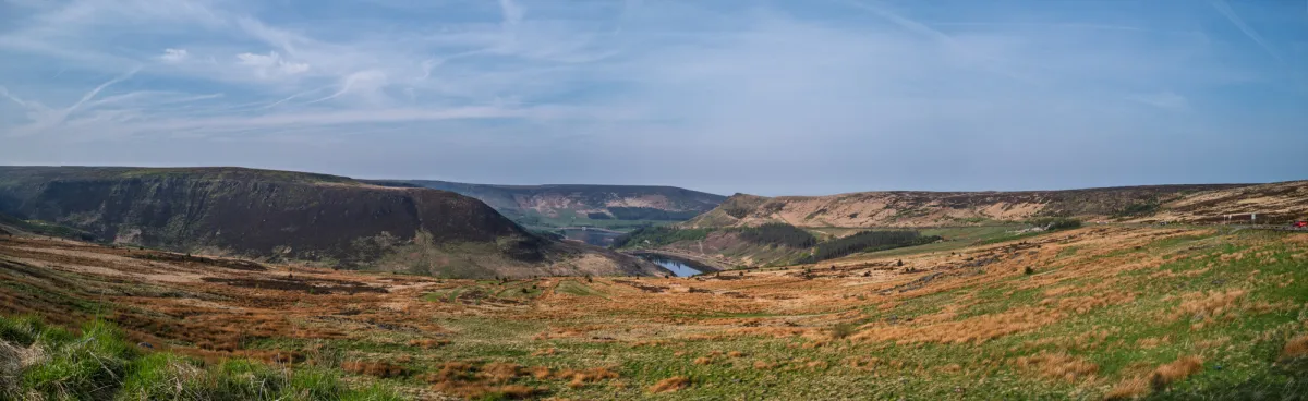 A wide panorama of moorland, with a reservoir in the valley below.