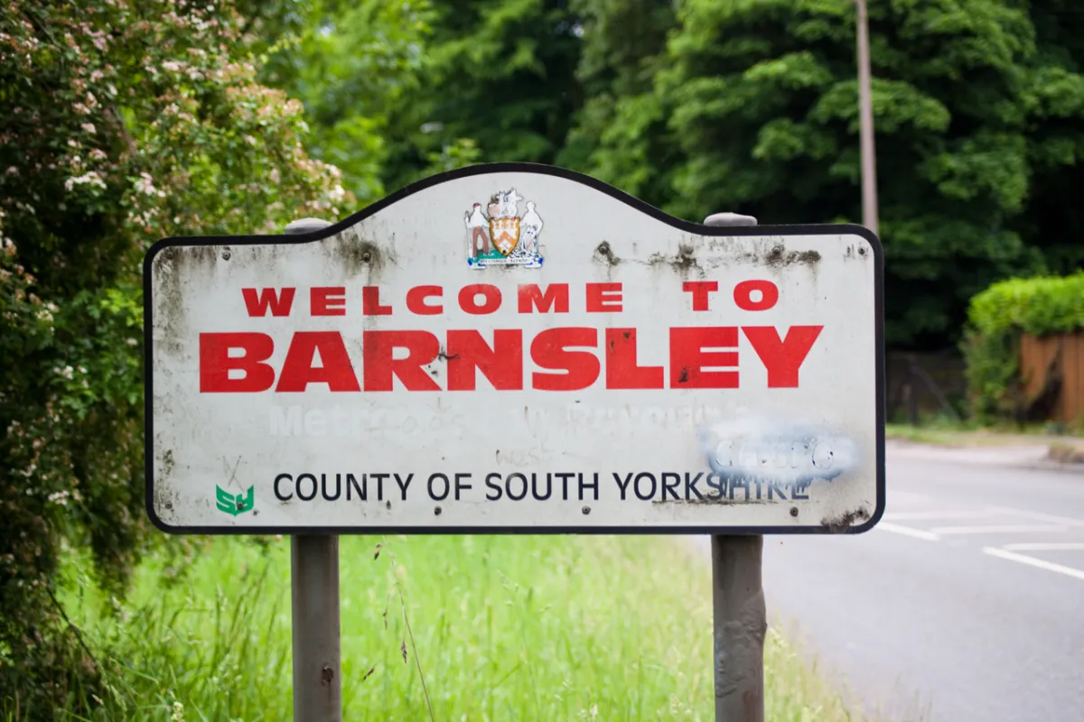 A weathered roadside sign reading Welcome to Barnsley, County of South Yorkshire.