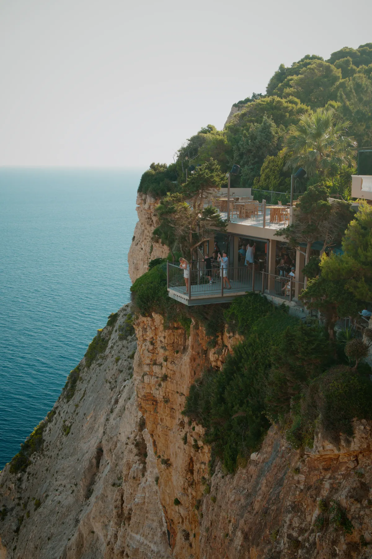 A café terrace built out over the edge of a high sea cliff.