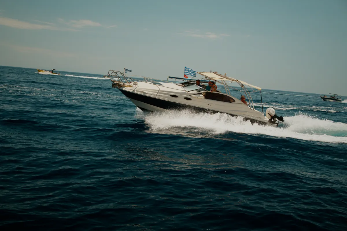 A motor cruiser under way, throwing up a wake.