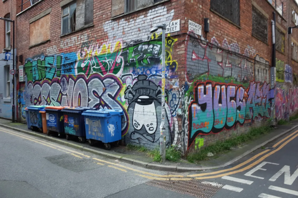 Graffitti adorns the brick walls on a corner building.